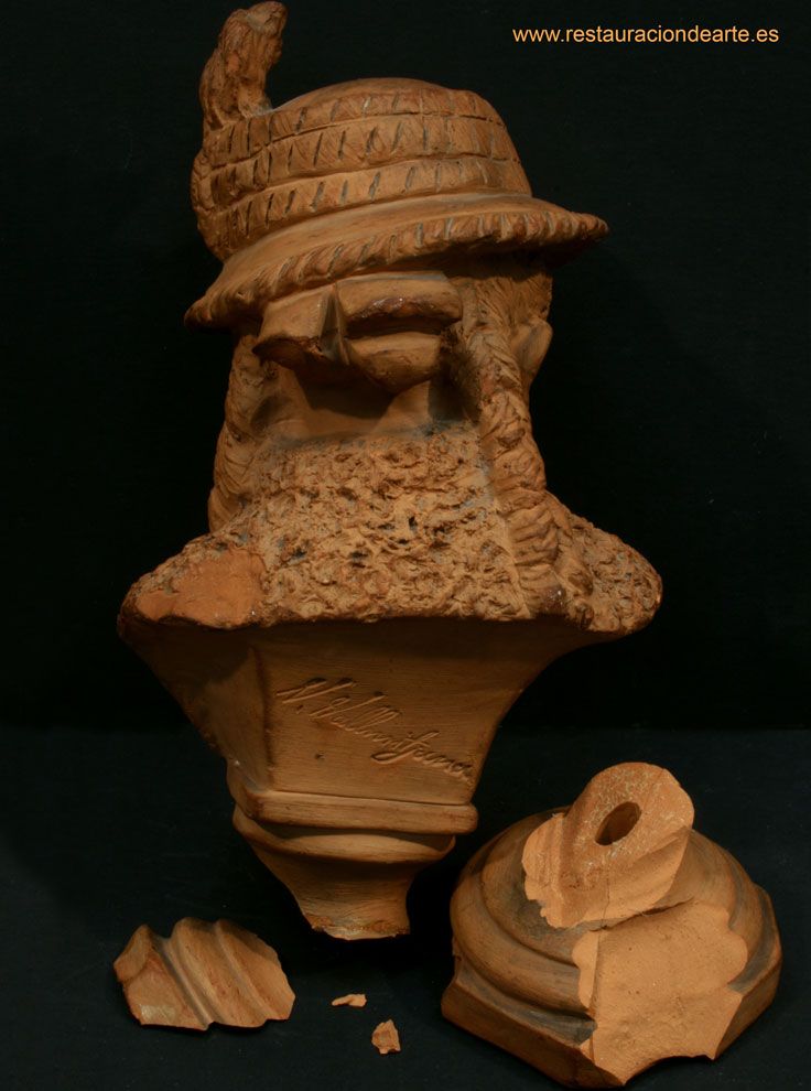 reverso de la escultura, foto inicial antes de la restauración, donde se observa la fractura de la base.