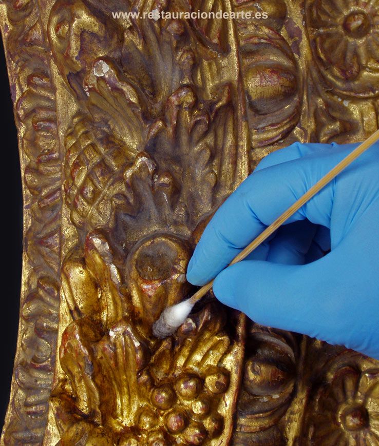 fotografía durante el proceso de limpieza de suciedad barniz oxidado en el taller de restauración de marcos en Madrid, tondo tallado y dorado, proceso de restauración