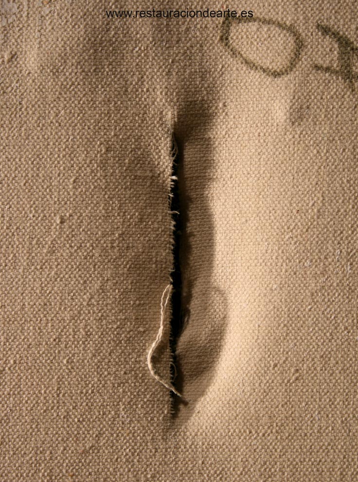 Fotografía antes de la restauración con deterioros, cuadro rajado visto por el reverso