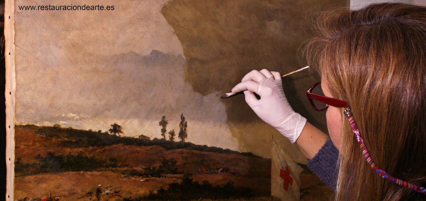 limpieza de cuadro por la restauradora de pintura